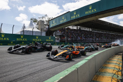 Lando Norris, McLaren MCL60, leads Sir Lewis Hamilton, Mercedes F1 W14, Fernando Alonso, Aston Martin AMR23, and Lance Stroll, Aston Martin AMR23, at the start as Kevin Magnussen, Haas VF-23, and Alex Albon, Williams FW45, crash out in the background